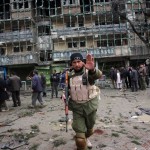 An Afghan security officer tries to stop