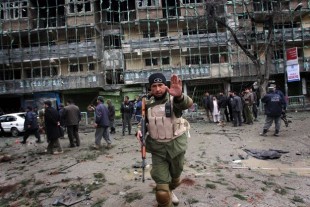An Afghan security officer tries to stop