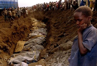 A Rwandan genocide survivor looks upon a mass grave outside Kigali in 1994.