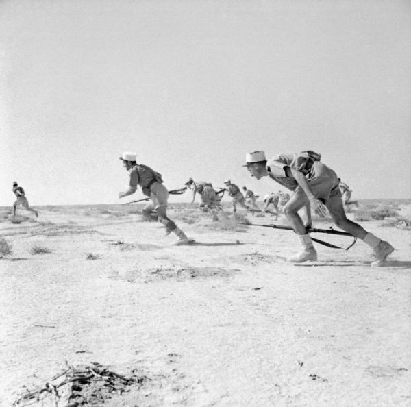 ‘A corps that could be sacrificed’: A legionnaire stands guard in Morocco, circa 1920 (top) and legionnaires under fire during the Battle of Bir Hakeim in Libya in 1942 (bottom).